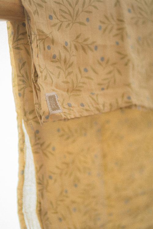 Lange en mousseline – Motif branches, feuilles et baies bleues sur fond moutarde